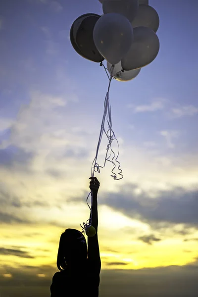 Gün batımı gökyüzü arka planda el tutan balonlar — Stok fotoğraf