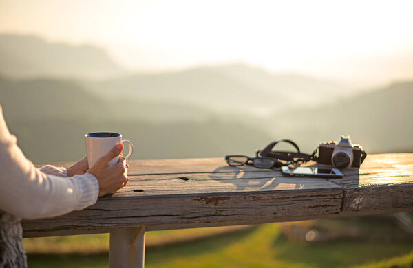 Woman drinking coffee in sun sitting outdoor in sunshine light enjoying her morning coffee, vintage,
