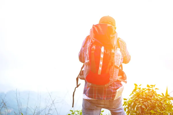 Турист с рюкзаком проверяет карту, чтобы найти направление в дикой местности — стоковое фото
