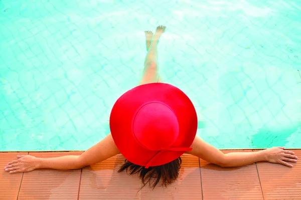 Mulher de chapéu grande relaxante na piscina — Fotografia de Stock