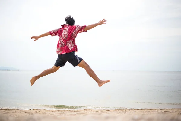 Atlama bir tropikal plaj atletik genç adam yaz keyfi — Stok fotoğraf