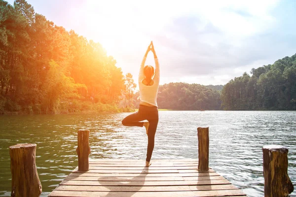 Здоровая женщина практикует йогу на мосту в природе — стоковое фото