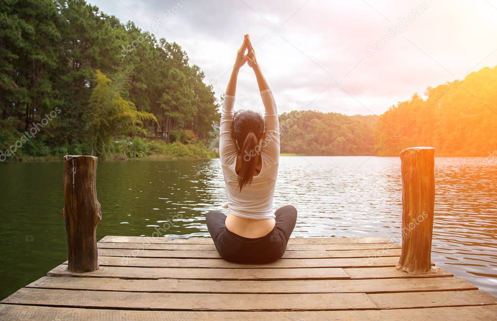 Woman do yoga outdoor. Woman exercising yoga at the nature background, select focus