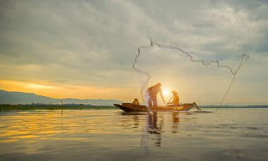 Fisherman of Bangpra Lake in action when fishing, Thailand clipart