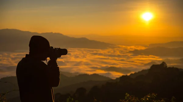 Silhouette des Fotografen, der Landschaft bei Sonnenuntergang fotografiert, weicher und ausgewählter Fokus — Stockfoto