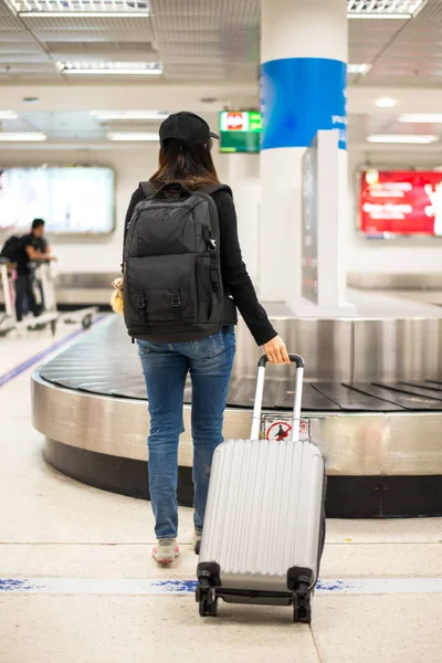 Женщины-путешественницы ждут сумку в зоне выдачи багажа в аэропорту — стоковое фото