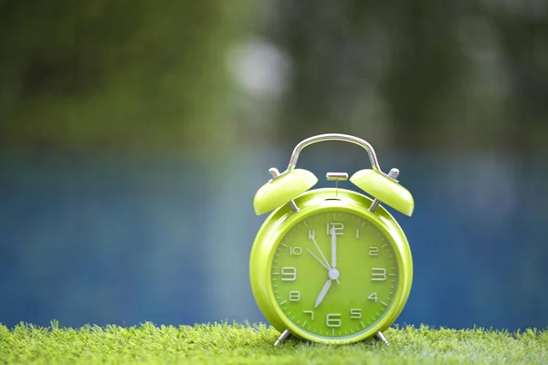 Relógio de alarme retro na mesa perto da piscina, tom verde — Fotografia de Stock