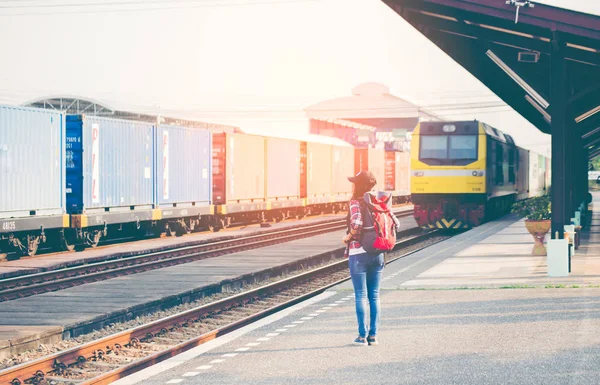 Travler レディースウォー キング一人で運ぶ荷物と待機の列車駅 — ストック写真