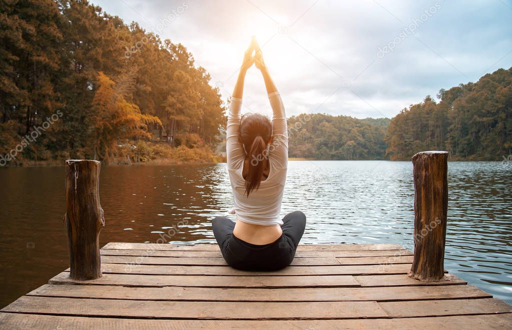 Woman do yoga outdoor. Woman exercising yoga at the nature background, select focus