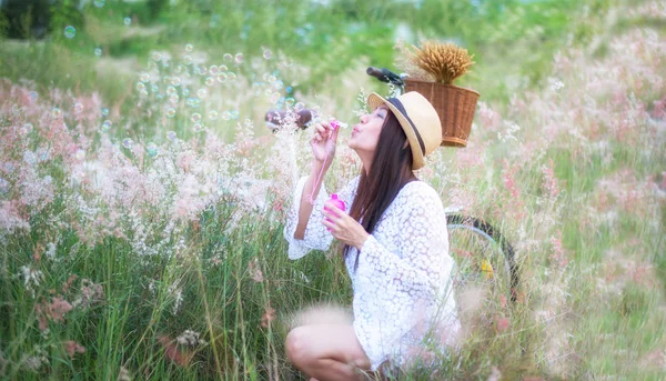 Femme soufflant des bulles dans la prairie. Voyage et coucher du soleil — Photo