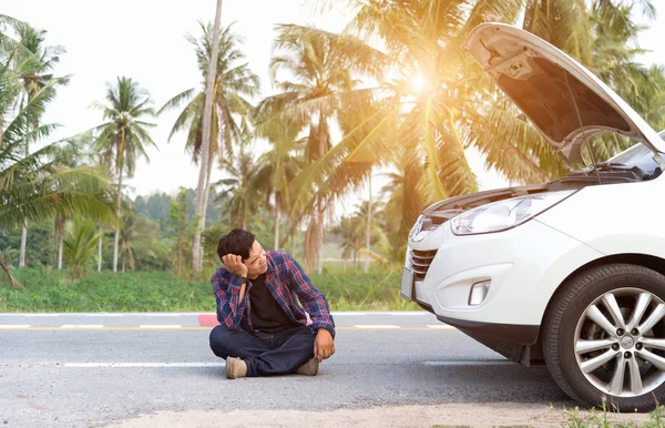 Stressed man sitting after a car breakdown at the side of the road — Stock Photo, Image