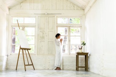 Taze kahve ile yaklaşıyor. Kahve içme ve çizim odasında bir pencereden bakıyor güzel genç kadın