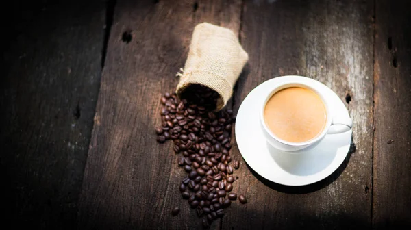 Tazza di caffè e chicchi di caffè sul tavolo — Foto Stock