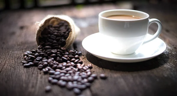 Tazza di caffè e chicchi di caffè sul tavolo — Foto Stock