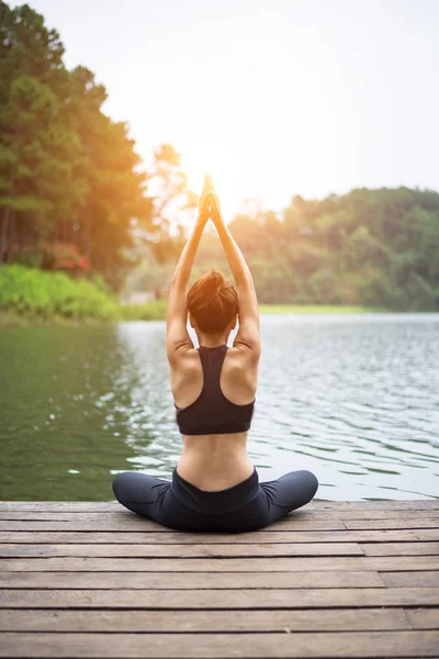 Femme saine pratiquant le yoga sur le pont dans la nature — Photo