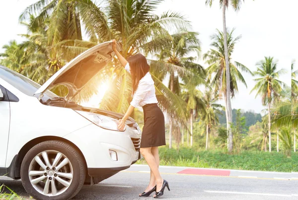 Mujer de negocios de pie junto a coche roto y mirando al motor — Foto de Stock