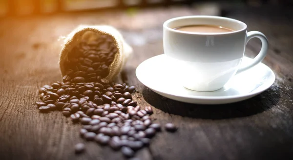Tazza di caffè e chicchi di caffè sul tavolo — Foto Stock
