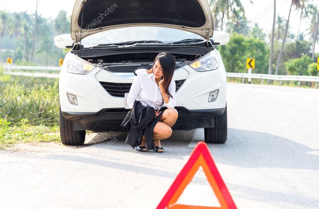 Business woman with a broken car calling for assistance