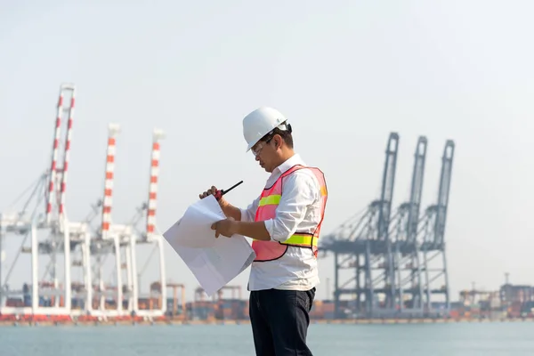 O engenheiro homem que trabalha com contêiner navio de carga no estaleiro ao entardecer para importação logística fundo de exportação — Fotografia de Stock