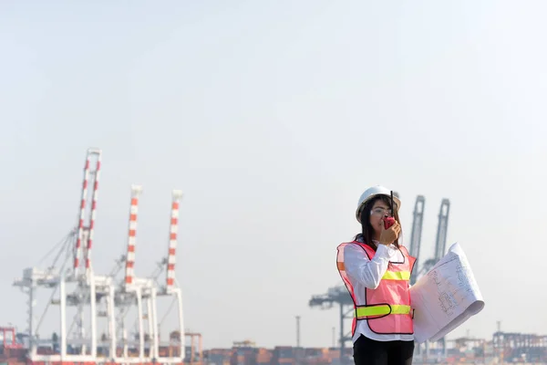 A nők mérnök dolgozik konténer szállítási teherhajó a hajógyár alkonyatkor importálása és exportálása logisztikai háttér — Stock Fotó