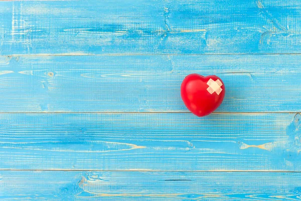 Ένα ενιαίο μόνο κόκκινη καρδιά αγάπη σχήμα χέρι μπάλα γυμναστικής στο μπλε ξύλινο — Φωτογραφία Αρχείου