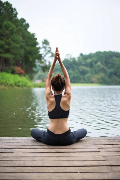Здоровая женщина практикует йогу на мосту в природе — стоковое фото