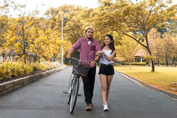 Happy couple riding bicycle in the park,copy space.