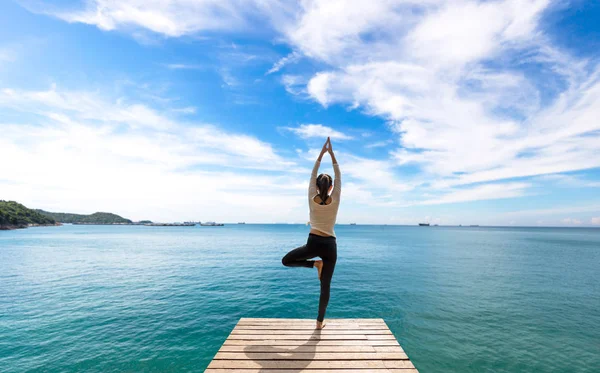 Femme caucasienne pratiquant le yoga au bord de la mer — Photo