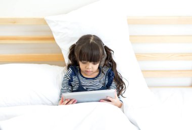 Sevimli kız yatakta, eğitim kavramı dizüstü arıyorum