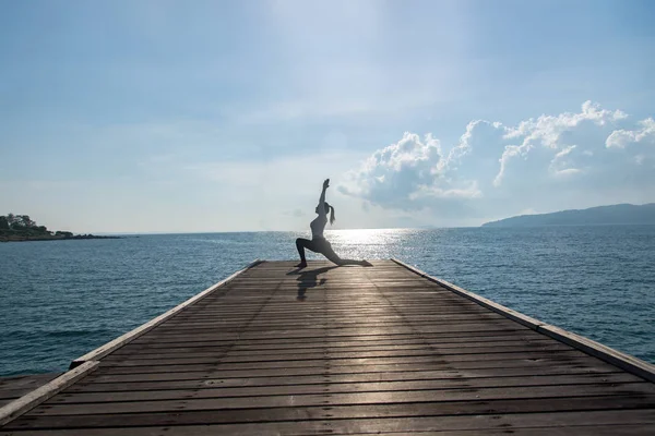 Femme caucasienne pratiquant le yoga au bord de la mer — Photo