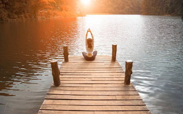 Frauen machen Yoga im Freien. Frau, die Yoga im Hintergrund der Natur ausübt, Fokus auswählen — Stockfoto