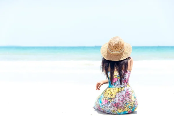 Mujer joven sentada en la playa mirando al mar y al cielo —  Fotos de Stock