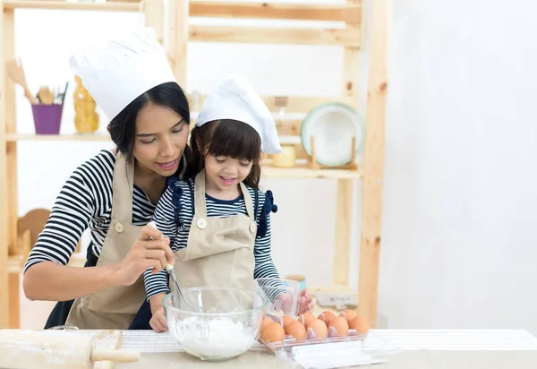 母亲和孩子的女儿妞妞是烹饪饼干和在厨房里有乐趣 — 图库照片