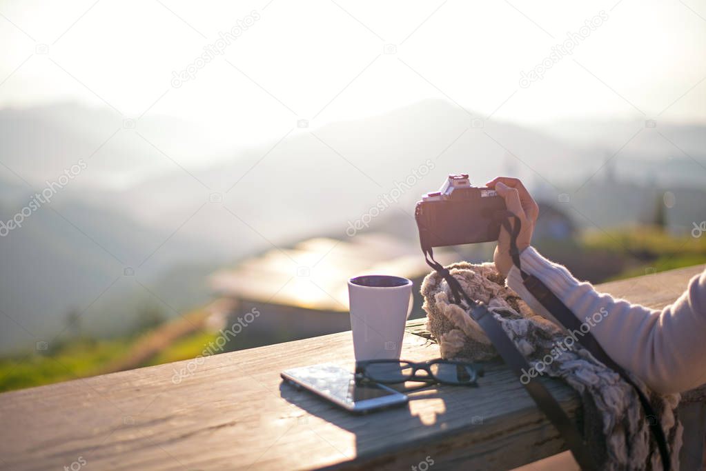 Woman drinking coffee in sun sitting outdoor in sunshine light enjoying her morning coffee, vintage, soft and select focus