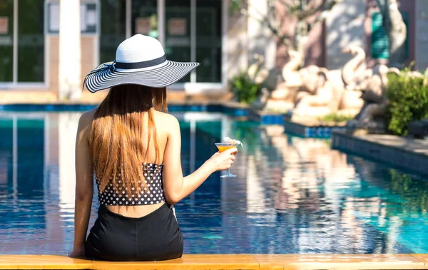 Mulher sorridente feliz com chapéu de palha na piscina — Fotografia de Stock