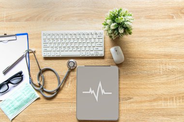 Doktor ile bir sağlık stetoskop onay kalbinde ahşap bir masa üstünde a laptop. Sağlıklı kavramı