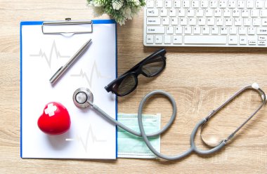 Doktor ile bir sağlık stetoskop onay kalbinde ahşap bir masa üstünde a laptop