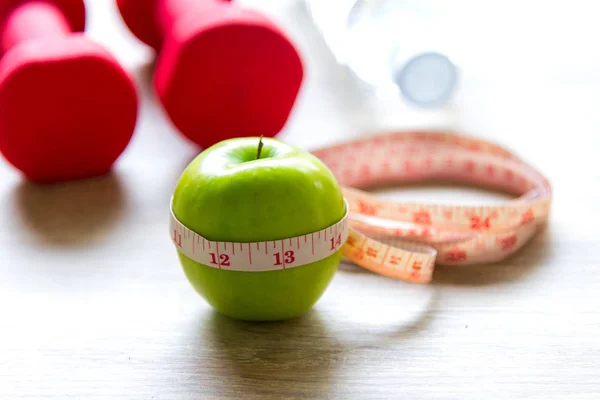 Healthy lifestyle for women diet with sport equipment, sneakers, measuring tape, fruit healthy green apples and bottle of water on wooden, select focus.  Healthy Concept. — Stock Photo, Image