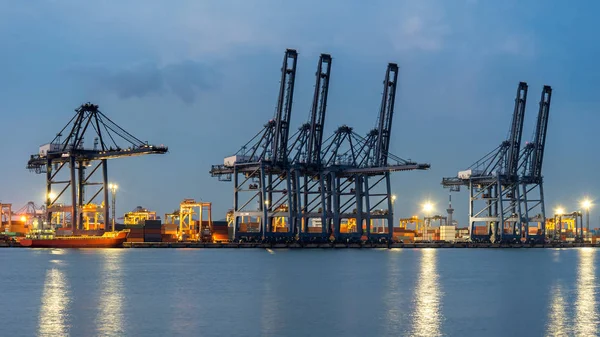 Konténer rakomány áru hajón szállít-val működő daru híd hajógyár alkonyatkor háttér logisztikai importálása és exportálása. Iparági koncepció — Stock Fotó