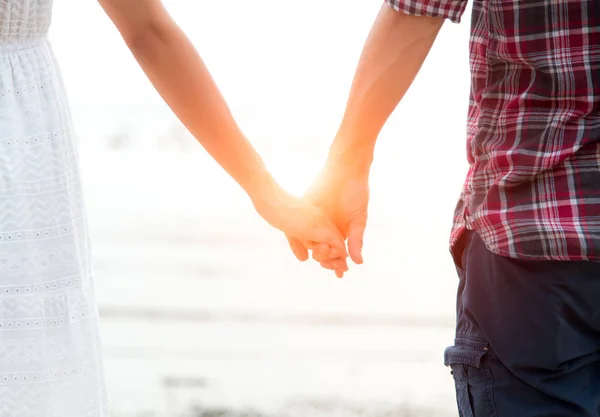 Junges verliebtes Paar, Attraktive Mann und Frau genießen romantischen Abend am Strand, Händchen haltend den Sonnenuntergang beobachtend — Stockfoto