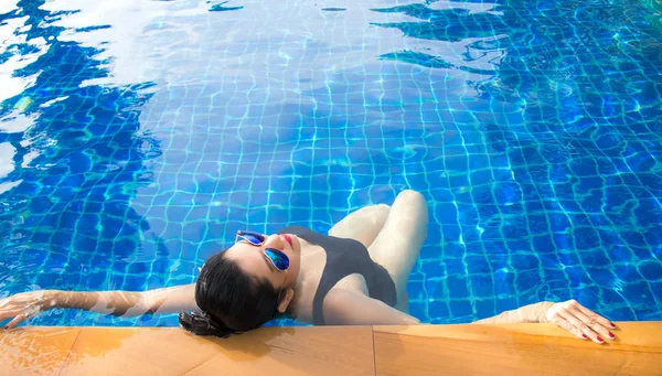 Estilo de vida das mulheres relaxante perto de banho de sol piscina de luxo, dia de verão no resort de praia no hotel. Conceito de Verão — Fotografia de Stock