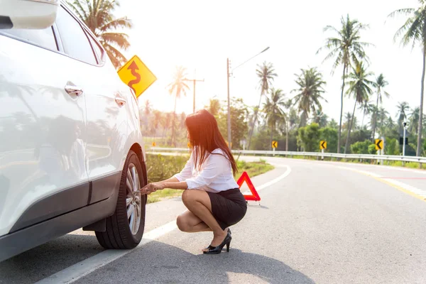 Business women driver changing tyre on her broken car. — Stock Photo, Image