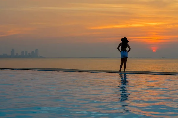 Jovem feliz em grande chapéu relaxante na piscina, viajar perto do mar e da praia ao pôr do sol. Conceito de Verão — Fotografia de Stock