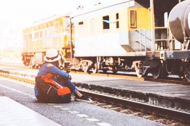 Seyahat ve Turizm kadınlar giyen bir tren, vintage sesi bekliyorsun holding harita ve içme kahve, sırt çantası. Seyahat kavramı.