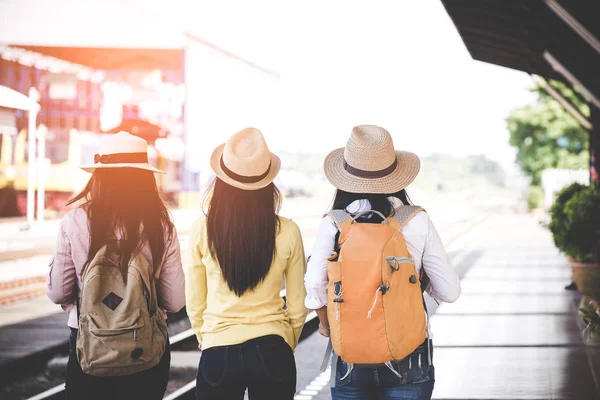 アジア女性旅行者と旅行バックパック地図を押しながら鉄道駅プラットフォームで待っている客のグループ。旅行の概念. — ストック写真
