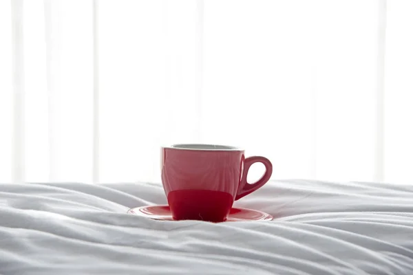 Café frais du matin en tasse rouge sur le lit — Photo