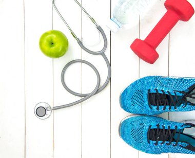 Diyet ve kilo kaybı tıbbi stetoskop, fitness ekipmanları, dokunma, tatlı su ve ahşap arka plan üstten görünüm üzerinde yeşil elma ölçme ile sağlıklı bakımı için. Sağlıklı kavramı.