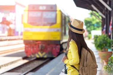 Bir tren bekliyorsun harita, holding sırt çantası takmış seyahat ve Turizm Asyalı kadınlar. Seyahat kavramı.