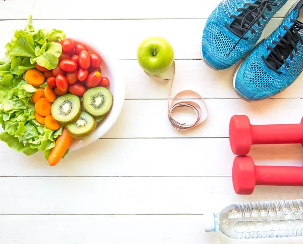 Stile di vita sano per le donne dieta con attrezzature sportive, scarpe da ginnastica, metro, verdura fresca, mele verdi e bottiglia d'acqua su legno. Concetto sano. — Foto Stock