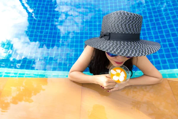 Estilo de vida Mulher em maiô relaxante e feliz com coquetel no chaise-longue perto da piscina, dia de verão. Conceito de Verão . — Fotografia de Stock